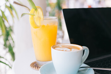 Cup of coffee and glass of fresh juice on table