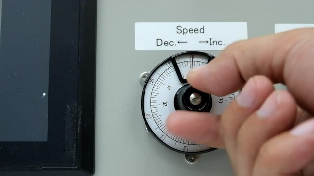 Close up hand grap and turn knob of scale dial meter rotation decrease gain from ten to zero unit
