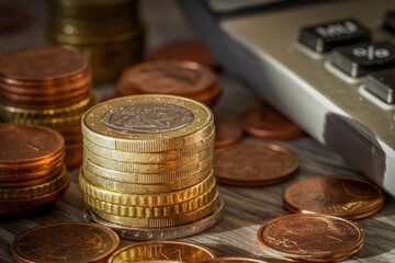 Coins and calculator on wooden table, business and finance concept