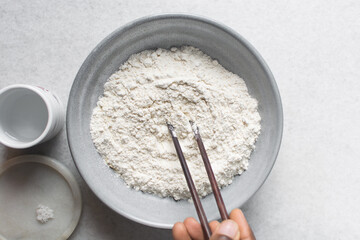 overhead view of All purpose flour in a bowl, top view of baking flour in a ceramic bowl