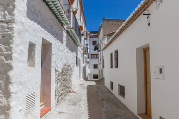 Narrow street with white houses in the old part of Chulilla, Spain