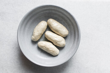 Overhead view of noodles dough in a grey bowl, top view of homemade biang biang noodles, process of making hand pulled noodles