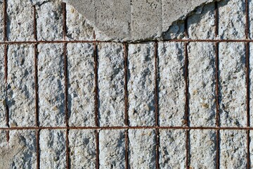 Close-up detail of a ruined concrete wall with exposed irons