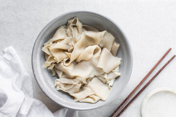 Overhead view of uncooked belt noodles, top view of raw biang biang noodles, process of making biangbiang mian