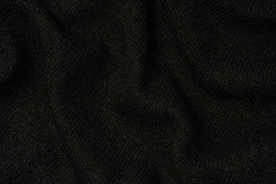 Dark grey sweater texture as a background. Knitted pattern.