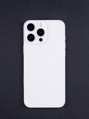 Close-up of modern white  smartphone with three cameras  on black  background