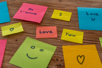 Plusieurs post-it de différentes couleurs sur une table avec des signes d'amour, de coeur, de...