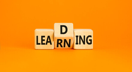 Learning or leading symbol. Concept words Learning Leading on wooden block. Beautiful orange table...
