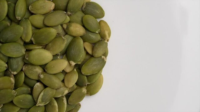 Macro video of pumpkin seeds on rotating disc. Close up of bunch of pumpkin seeds.
