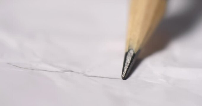 A macro closeup of a sharp wooden pencil point pressing gently against crumpled white paper. The intricate textures highlight creativity and precision in fine details.