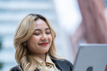 Fototapeta premium Stylish businesswoman walking in a modern urban setting with a coffee cup, exuding confidence, professionalism, and a dynamic career lifestyle in a sleek architectural city.