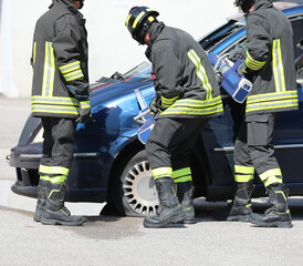 firefighters using powerful hydraulic cutters called jaws of life to cut through the wreckage of a...