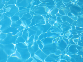background of the blue pool water with light reflections no people