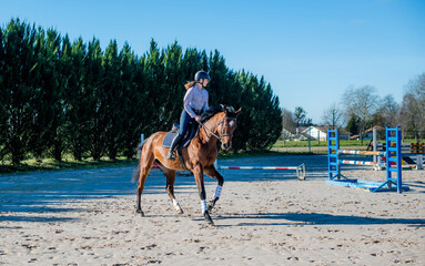 beautiful young woman riding her young mare outdoors