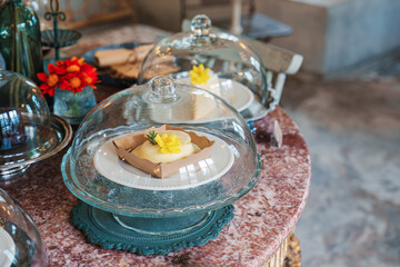 Various desert under glass dome on marble table decorated with antique style