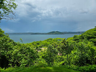 the blue waters of Culebra Bay, lush green trees, blue sky and clouds in Liberia Guanacaste Costa Rica