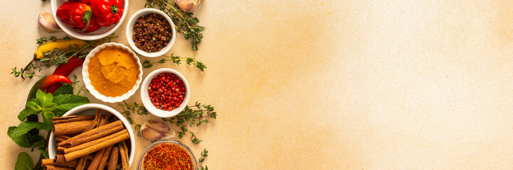 A warm display of spices and herbs on a beige background, each adding rich aromas and flavors,...