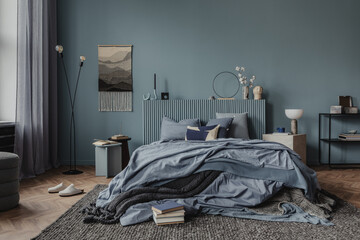 A cozy bedroom area adorned with textured throws, neutral-toned cushions, and warm lighting. Home decor. Blue tones.