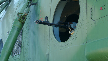 machine gun mounted in the window of a military helicopter