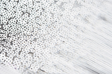 Abstract festive fabric texture with silver sequins.