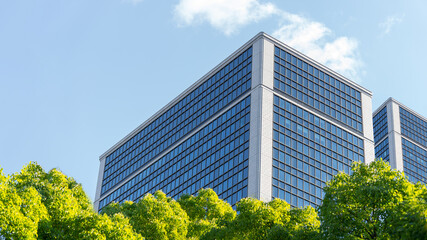 Eco-friendly building in modern city Sustainable glass office building with trees to reduce CO2...