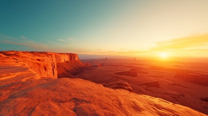 Naklejka premium Sunset over vast desert canyon landscape with red rock formations.