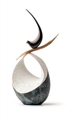 A detailed sculpture of a bird gracefully perched atop a sturdy stone, showcasing artistry and nature's beauty in a harmonious display.
