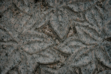 engraved tree leaves in granite. Carving texture background.