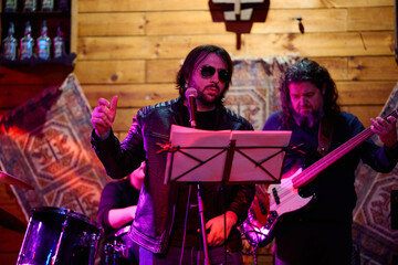 Live performance by a heavy metal band at a vibrant concert venue in the evening