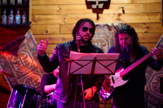 Live performance by a heavy metal band at a vibrant concert venue in the evening