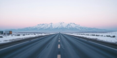 A scenic winter highway vanishing point towards a majestic snow-capped mountain range under a soft pastel sky