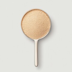 A close-up view of a Fine granules of dry yeast in a measuring spoon, showcasing its texture and color for culinary use.