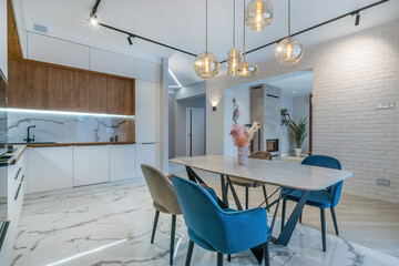 Spacious kitchen with elegant interior design. The doorway to the living room with a fireplace.