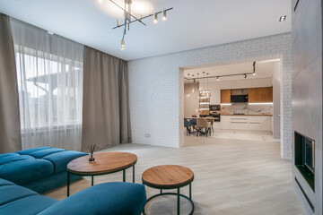 Modern interior. Living room with sofa and fireplace, doorway to the kitchen. Open floor plan.