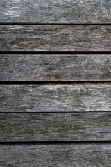 Obraz premium Close-up of weathered wooden planks showcasing a rustic, aged surface with natural grooves and mossy green hues. Perfect for backgrounds, design projects