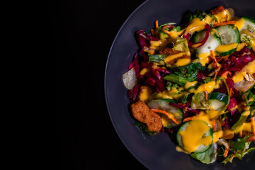 The rich textures and colors of this fresh vegetable salad are enhanced by a drizzle of golden dressing. Featuring slices of cucumber, lettuce leaves, and thinly shredded carrots.