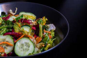 A close-up of a gourmet salad reveals a medley of fresh vegetables. The vibrant colors and textures highlight the freshness of the ingredients.