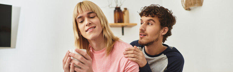 Two men share a tender moment in a warm, inviting room, radiating happiness and affection.