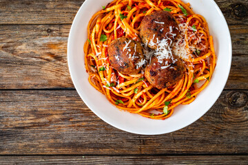 Spaghetti meatballs in tomato sauce on wooden table	
