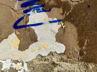 Abstract urban wall texture with blue spray paint on cracked concrete surface