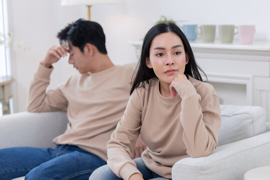 Relationship struggle between a couple sitting on a couch in a living room during a tense conversation