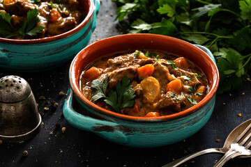 Beef goulash with vegetables on black table