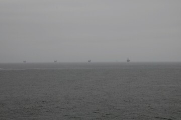 A line oil oil rigs floating in a fog off the coast of Santa Barbara