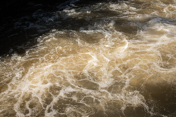 Fototapeta premium Close up of splashing and foaming water in river rapids.