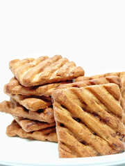 Delicious freshly baked chocochip cookies on a plate isolated over white background.Sugar chocolate biscuits stacked.Sweet foods cause diabetes.Tempting tasty baked cookies ready to be served.