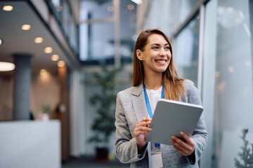 Happy female manager using touchpad while working at corporate office.