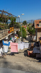 Fototapeta premium Laundry is dried on rope on street in Fethiye, Turkey. Everyday life of local residents. Drying clothes outdoors. Vertical image
