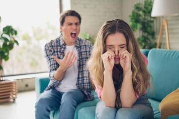 Distressed couple arguing in a cozy home interior with emotions running high