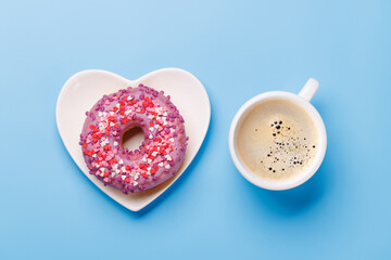 A vibrant donut on a heart-shaped saucer and a coffee cup, perfect for a Valentines Day card