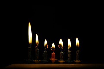 Six Lit Candles in the Dark Emitting a Warm Glow and Creating Smooth Shadows